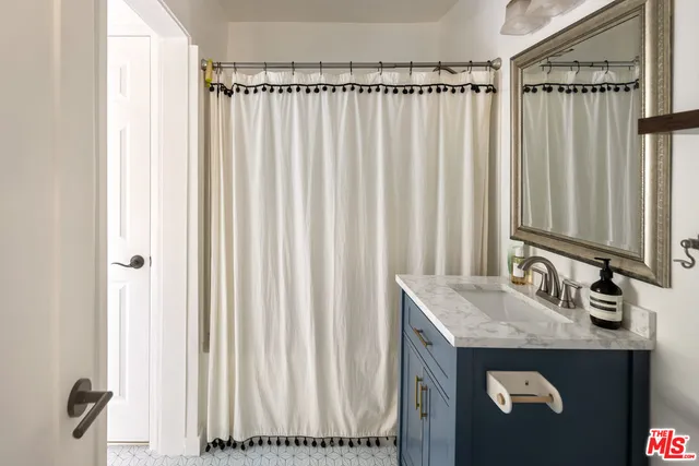 a bathroom with a granite countertop sink and a mirror