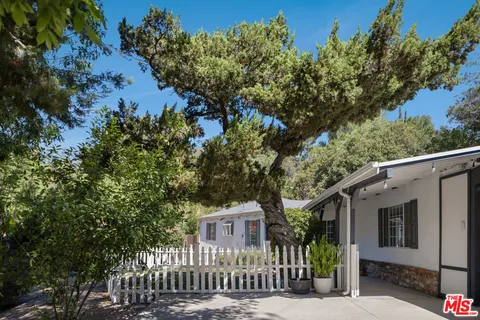 a front view of a house with a tree