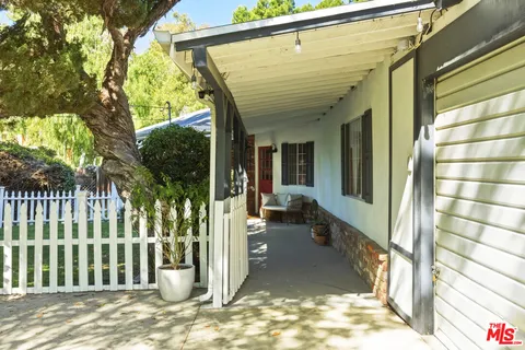 a living room with stainless steel appliances furniture a rug and a view of kitchen