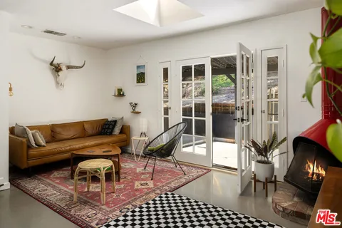 a living room with furniture a rug and a floor to ceiling window