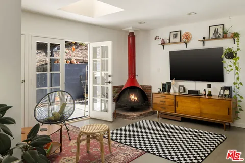 a living room with furniture a rug and a floor to ceiling window