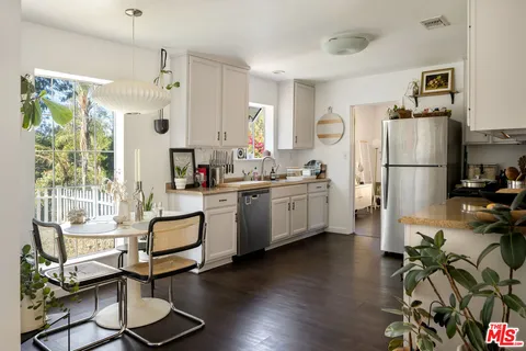 a kitchen with white cabinets and white appliances