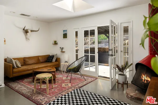 a living room with furniture a rug and a floor to ceiling window