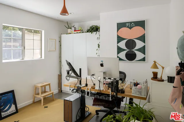 a view of a workspace with furniture and a window
