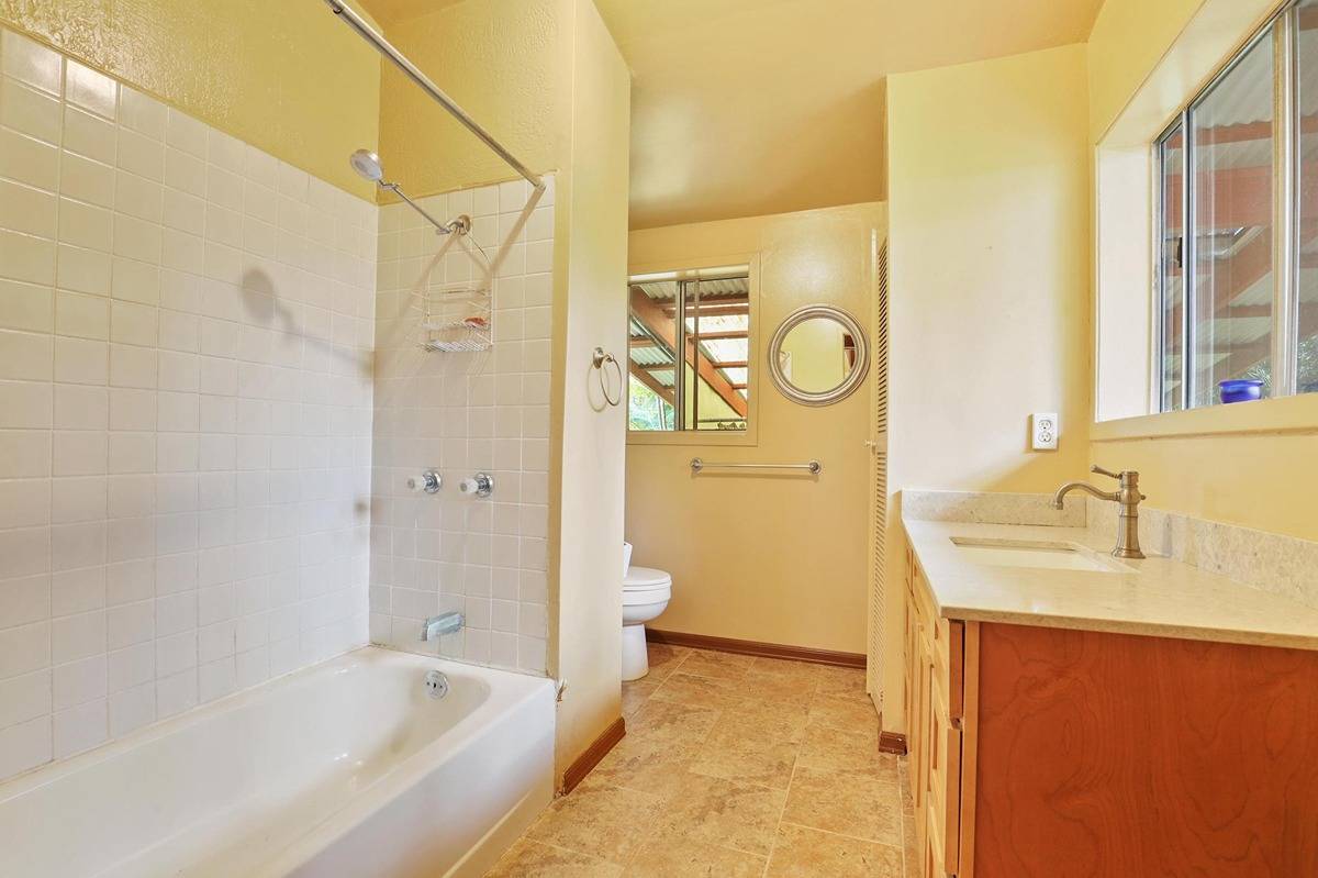 16-1585 Hopue Road, Unit 2 Mountain View, HI 96771 - Photo 11 of 29 a bathroom with a granite countertop sink a toilet and shower