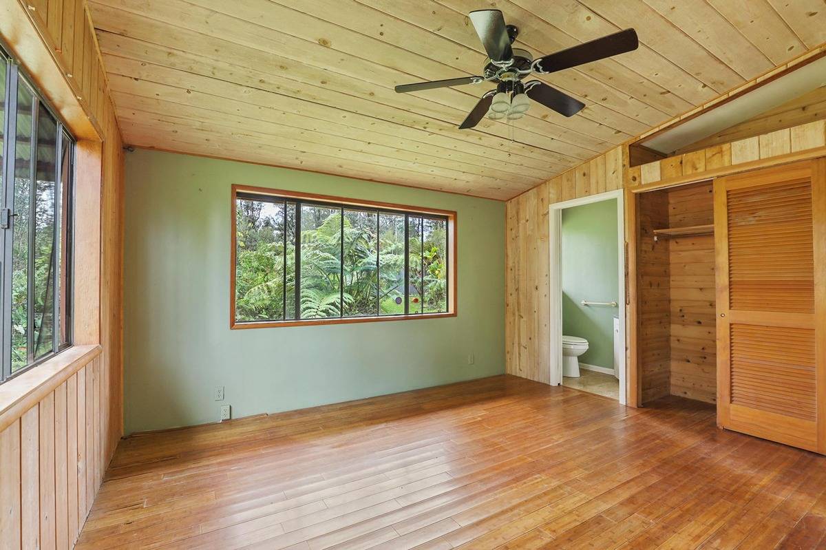 16-1585 Hopue Road, Unit 2 Mountain View, HI 96771 - Photo 13 of 29 an empty room with wooden floor and windows