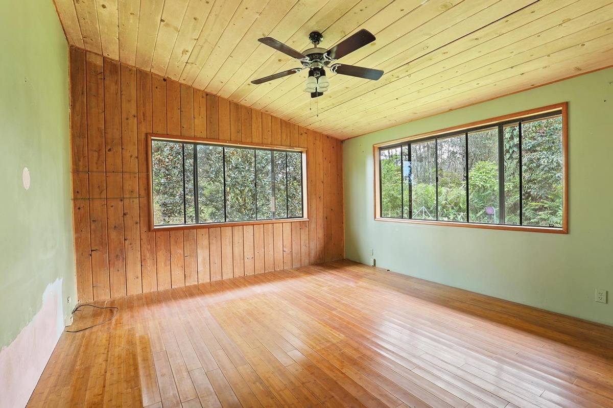 16-1585 Hopue Road, Unit 2 Mountain View, HI 96771 - Photo 14 of 29 a view of an empty room with a window and wooden floor