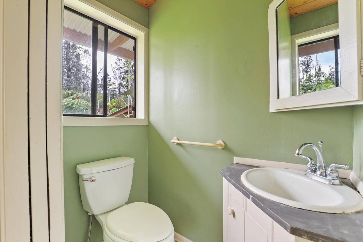16-1585 Hopue Road, Unit 2 Mountain View, HI 96771 - Photo 16 of 29 a bathroom with a toilet sink and mirror