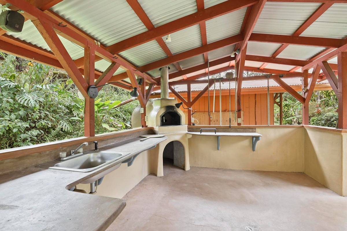 16-1585 Hopue Road, Unit 2 Mountain View, HI 96771 - Photo 19 of 29 a kitchen with a sink and large windows