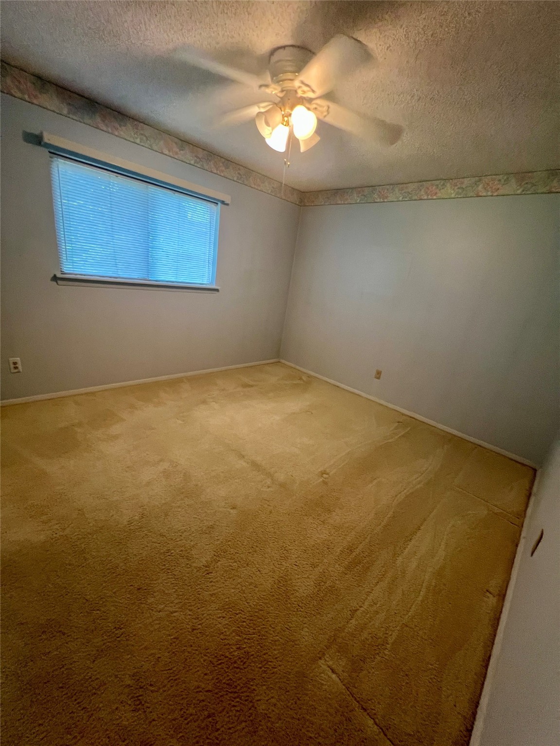 307 Jill Street Conroe, TX 77303 - Photo 9 of 20 an empty room with a chandelier fan and windows