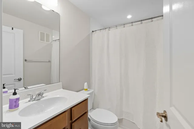 a bathroom with a sink a toilet and shower curtain