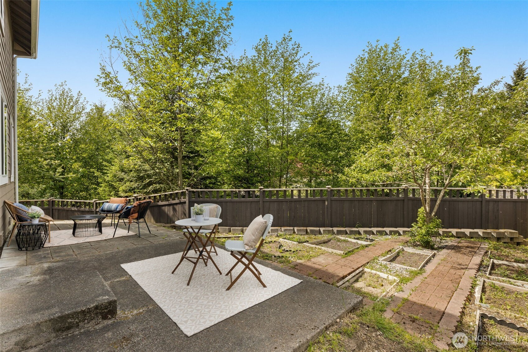 18525 115th Place Southeast Renton, WA 98055 - Photo 26 of 29 a view of a patio with table and chairs and potted plants with wooden floor and fence