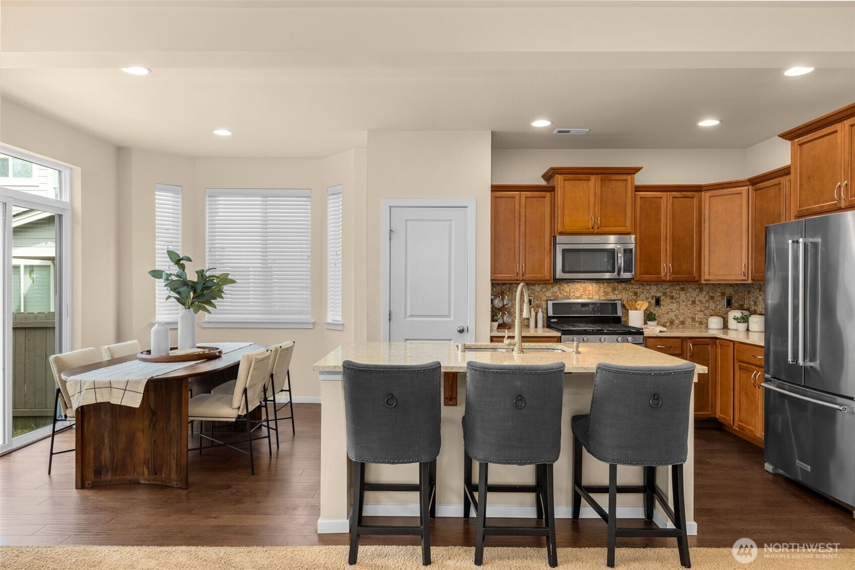 18525 115th Place Southeast Renton, WA 98055 - Photo 4 of 29 a kitchen with stainless steel appliances a dining table chairs refrigerator and sink