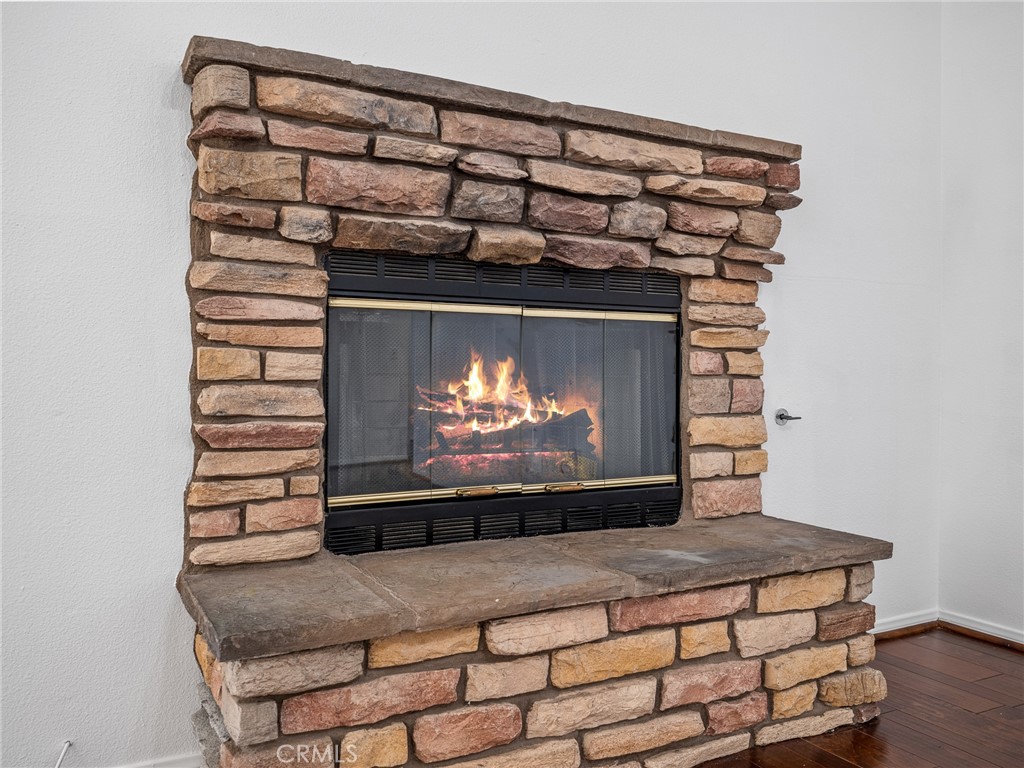 14266 Kiowa Road Apple Valley, CA 92307 - Photo 12 of 27 Spacious living room with cozy fireplace and laminate flooring, creating a warm and inviting gathering space.