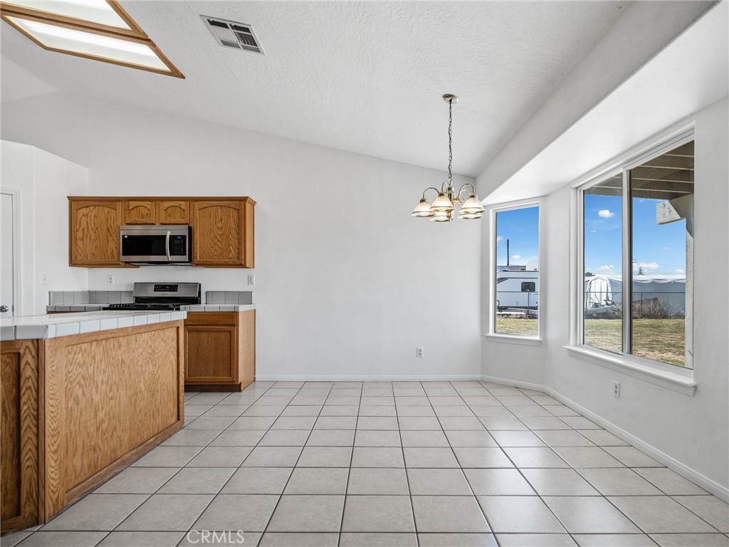 14266 Kiowa Road Apple Valley, CA 92307 - Photo 13 of 27 Bright dining space surrounded by windows, offering beautiful views of the acre lot and easy access to the covered patio.