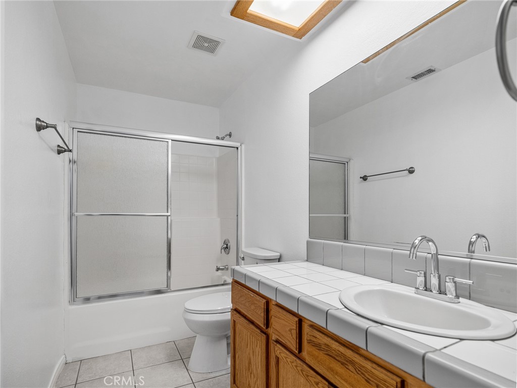 14266 Kiowa Road Apple Valley, CA 92307 - Photo 16 of 27 Bathroom includes a fully enclosed sliding glass shower, offering a sleek look and easy upkeep.