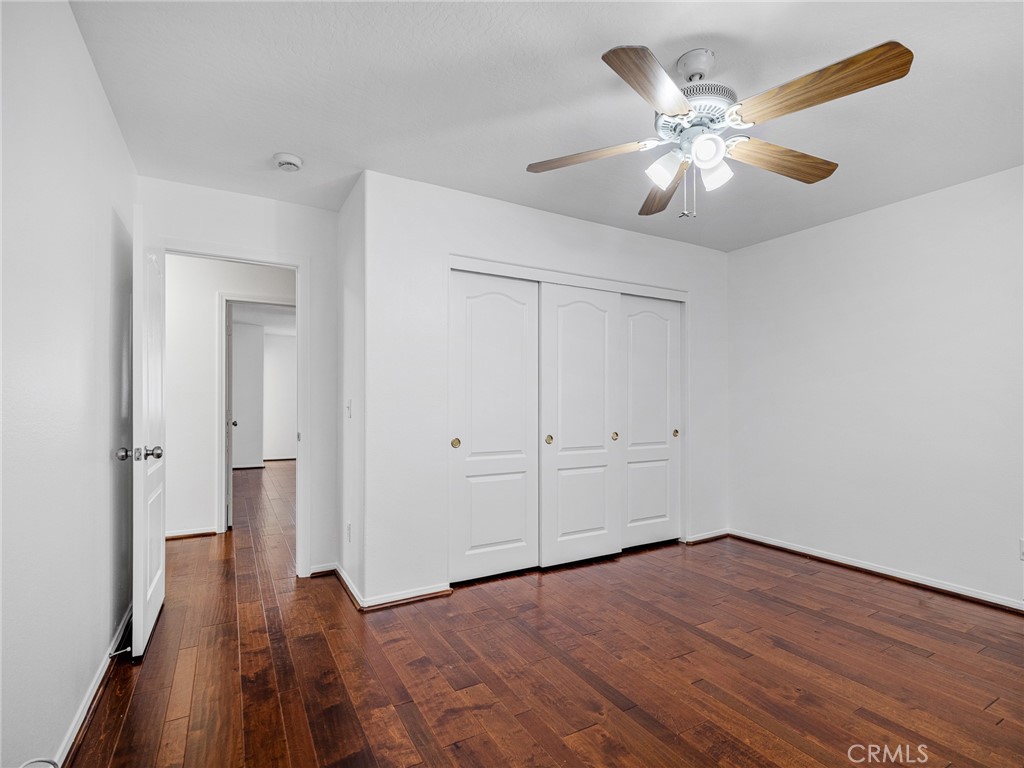14266 Kiowa Road Apple Valley, CA 92307 - Photo 18 of 27 Comfortable bedroom with laminate flooring, ceiling fan, and fresh interior paint.