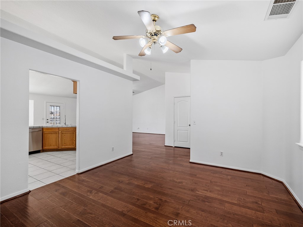 14266 Kiowa Road Apple Valley, CA 92307 - Photo 20 of 27 Spacious primary bedroom featuring laminate flooring, ceiling fan, and ample natural light. Comfortable retreat with convenient access to the en-suite bathroom.