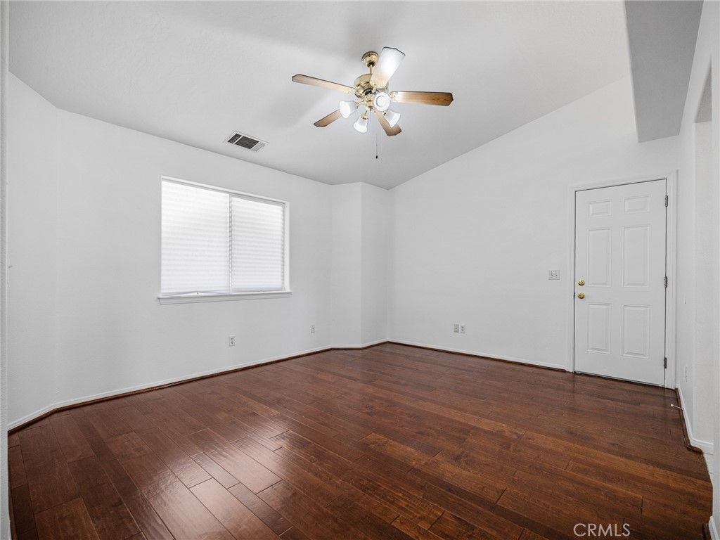 14266 Kiowa Road Apple Valley, CA 92307 - Photo 22 of 27 Spacious bedroom featuring ceiling fan, laminate flooring, and dual sliding closet doors.