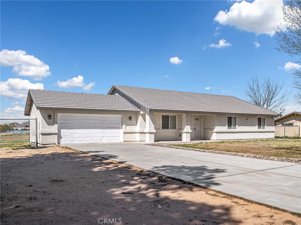 14266 Kiowa Road Apple Valley, CA 92307 - Photo 4 of 27 Long concrete driveway providing ample parking, RV access, and room for multiple vehicles or recreational toys.