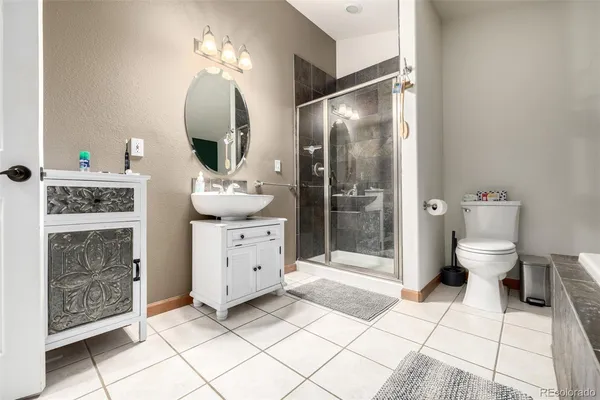 a spacious bathroom with a mirror sink and toilet