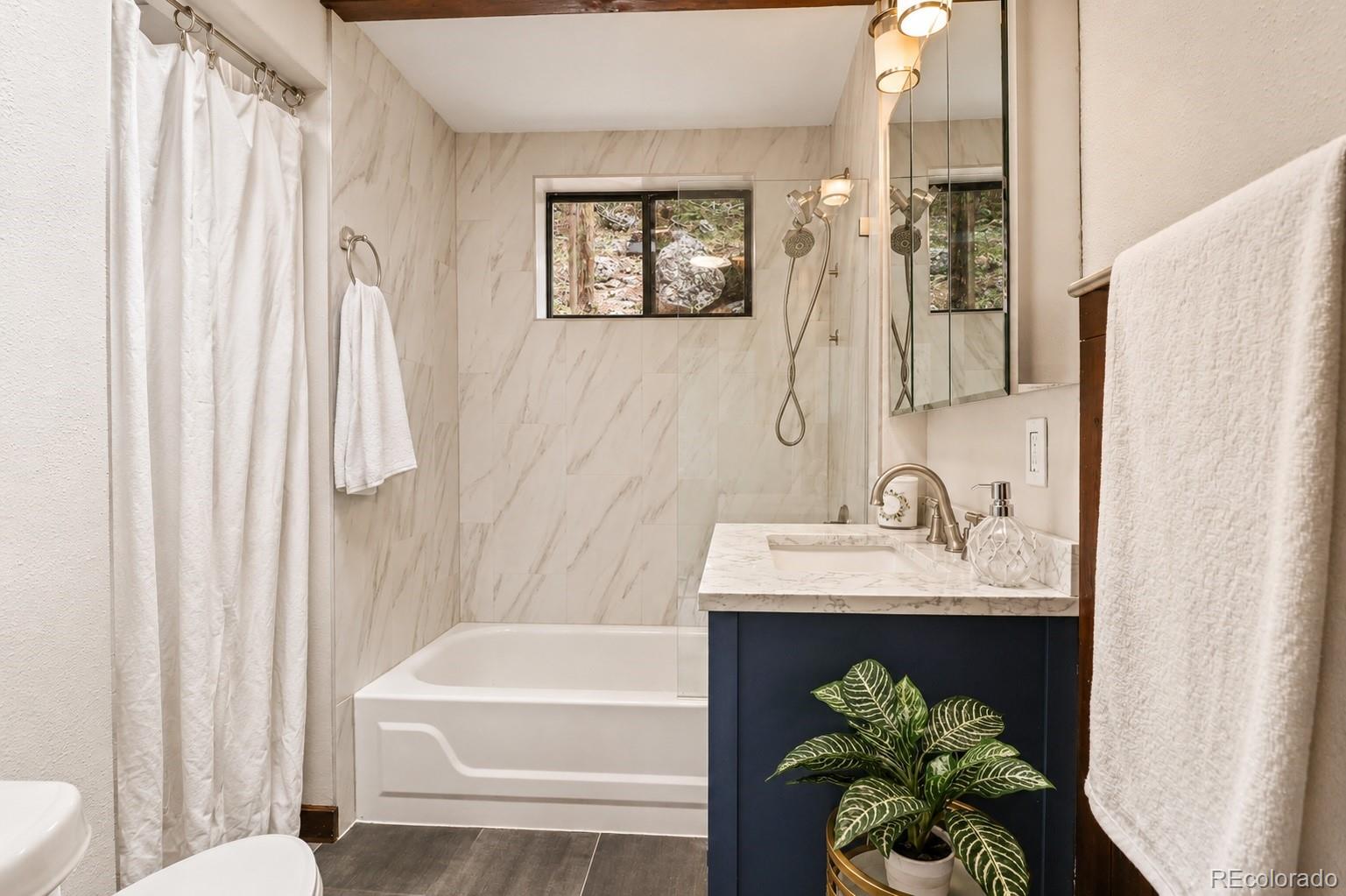 7520 South Blue Creek Road Evergreen, CO 80439 - Photo 14 of 22 a bathroom with a sink a toilet and a bathtub