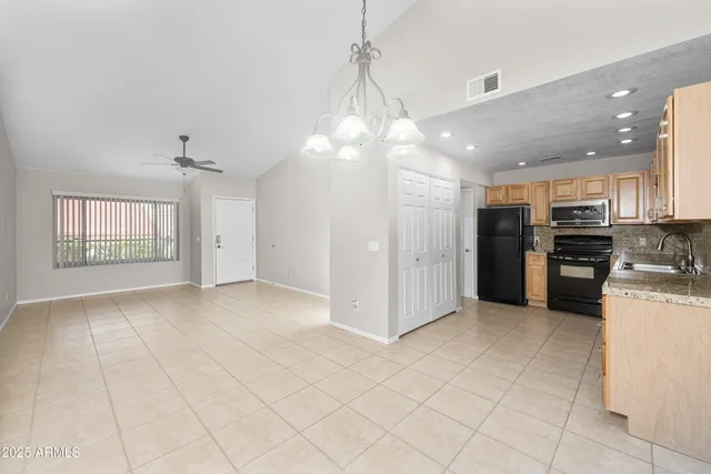 a large kitchen with stainless steel appliances granite countertop a refrigerator and a sink