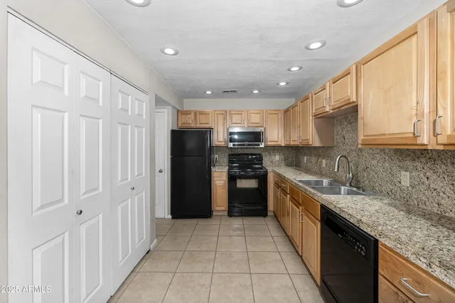 a kitchen with stainless steel appliances granite countertop a refrigerator and a sink