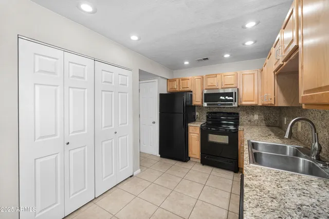 a kitchen with granite countertop a stove and a microwave