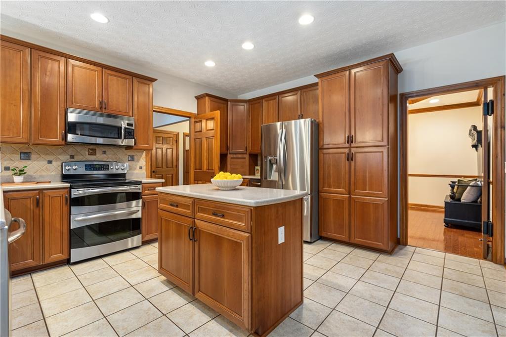 4275 Burtner Road Natrona Heights, PA 15065 - Photo 13 of 42 a kitchen with stainless steel appliances granite countertop a refrigerator stove and sink