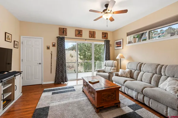 a living room with furniture a flat screen tv and a floor to ceiling window