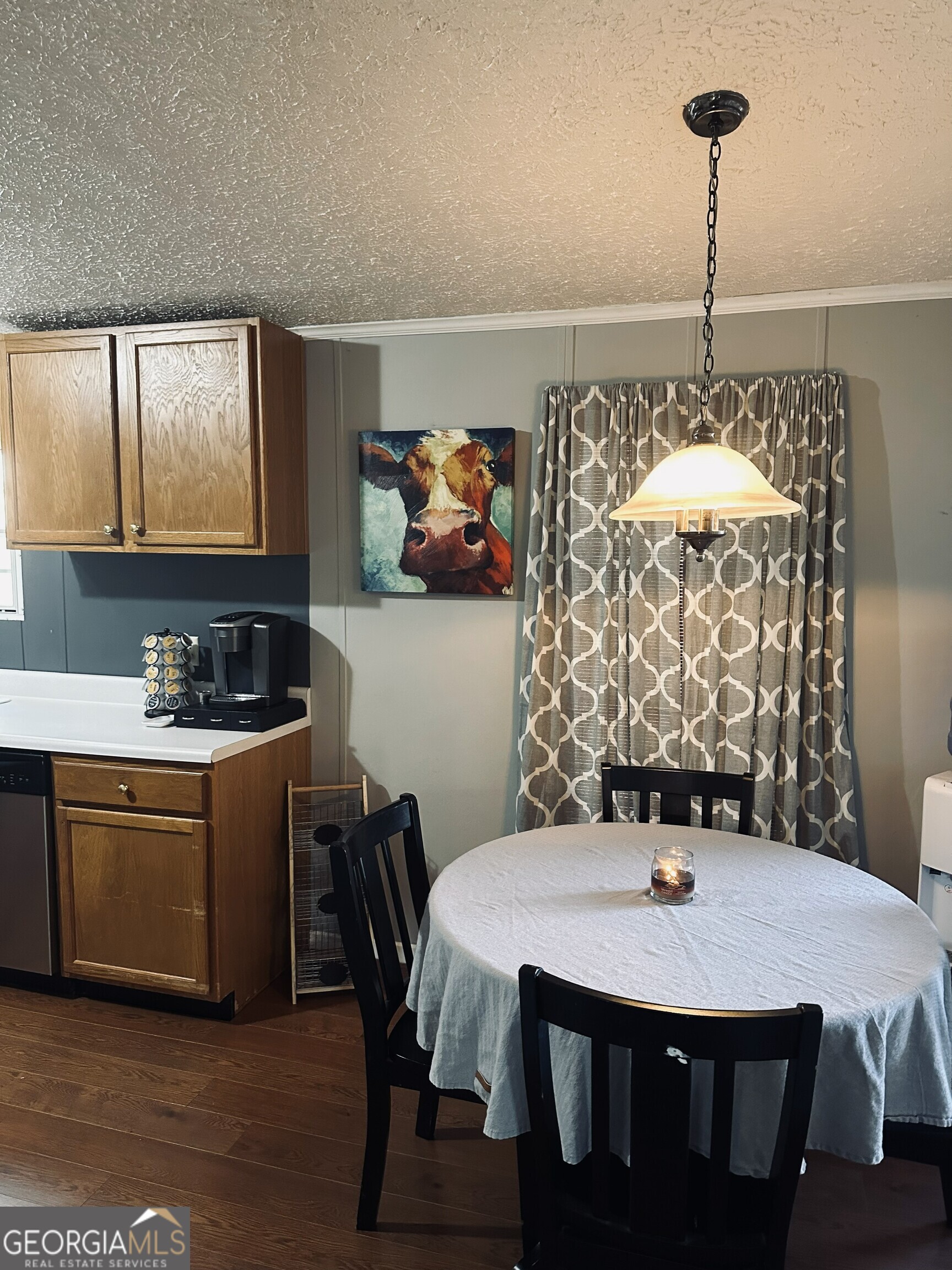 6675 Millwood Road, Unit 1B Gainesville, GA 30506 - Photo 7 of 10 a kitchen with a table chairs and white cabinets
