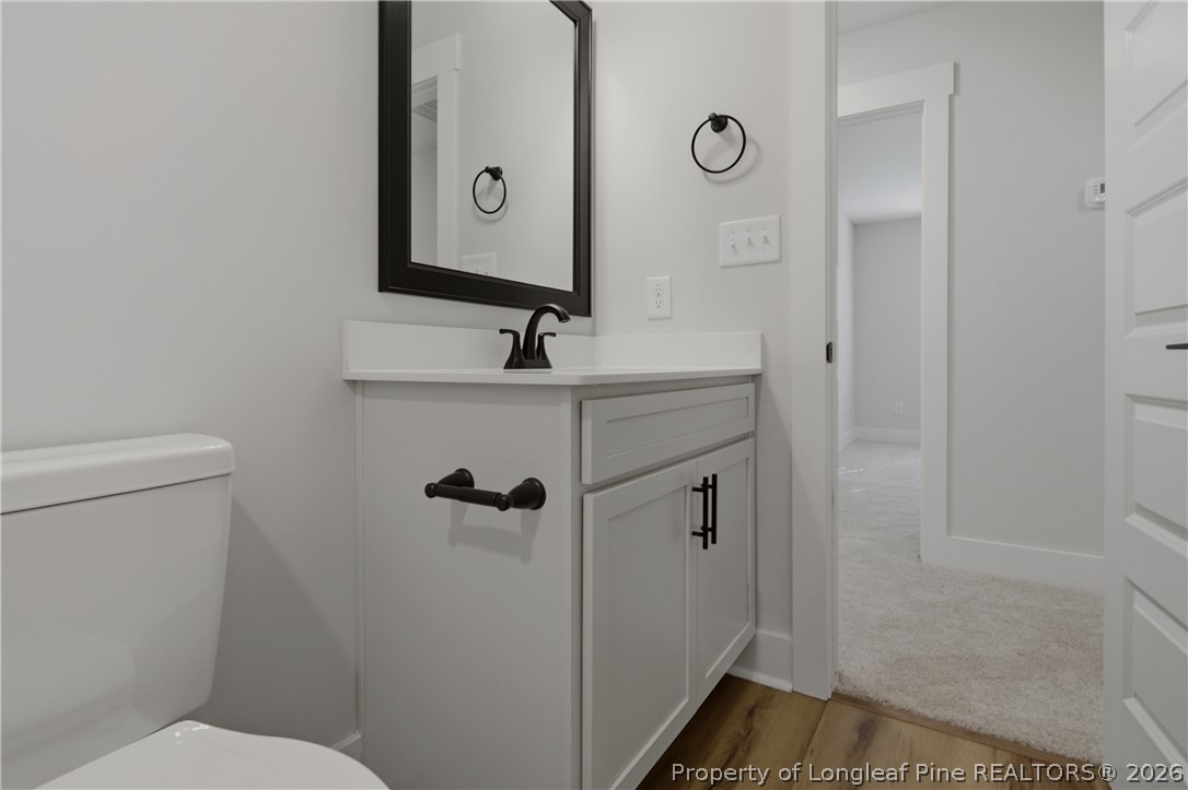 3931 Hamilton Street Hope Mills, NC 28348 - Photo 42 of 50 a bathroom with a sink a toilet a mirror and shower