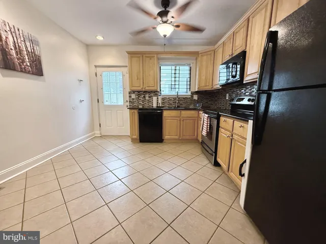 a kitchen with granite countertop a refrigerator and a stove top oven