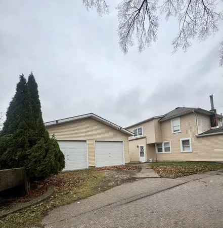 a view of a house with a yard and garage