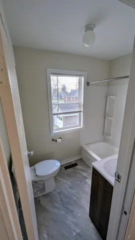 a bathroom with a sink toilet and a window