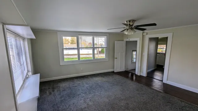 a view of a livingroom with a ceiling fan and window