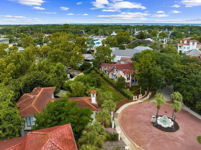 an aerial view of residential houses with outdoor space and trees