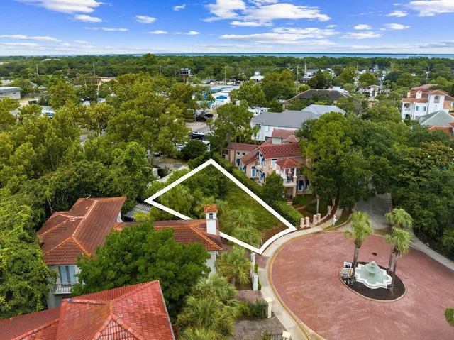 an aerial view of residential houses with outdoor space and trees