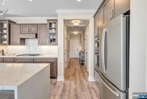 a view of a kitchen with a sink and dishwasher with wooden floor