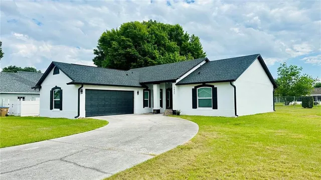 a front view of a house with yard and garage