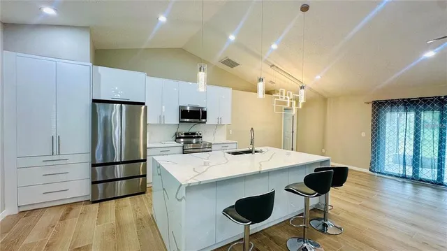 a kitchen with a refrigerator a stove and a sink