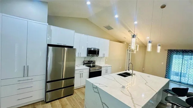 a living room with a table chairs and a wooden floor
