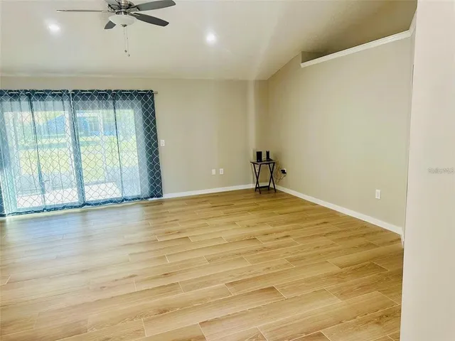 a view of an empty room with wooden floor