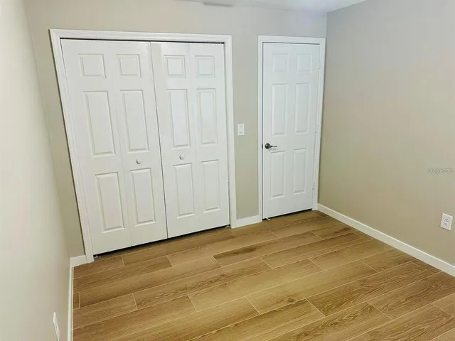 a view of a room with wooden floor and a window