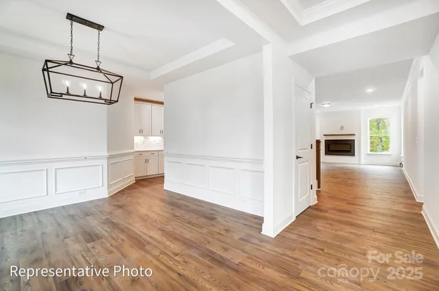 a view of a room with wooden floor staircase and kitchen view