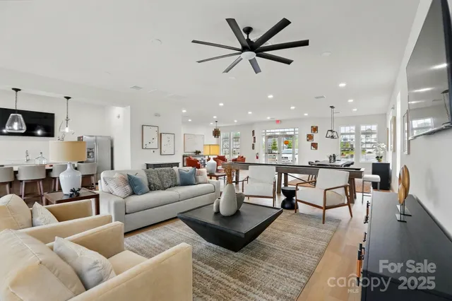 a living room with furniture and a view of kitchen