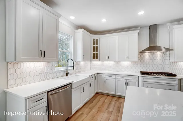 a kitchen with stainless steel appliances granite countertop a sink stove and cabinets