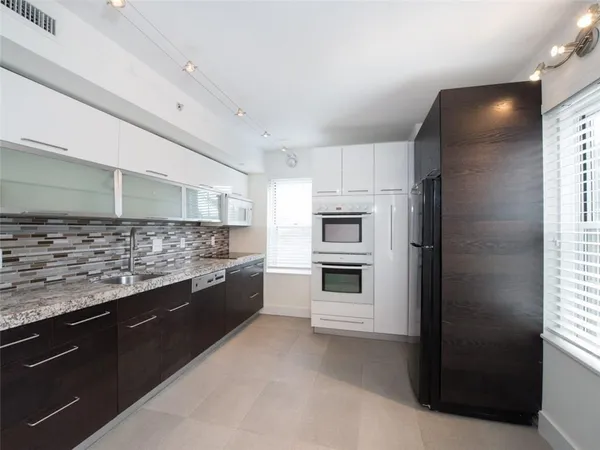 a kitchen with granite countertop a refrigerator and stove