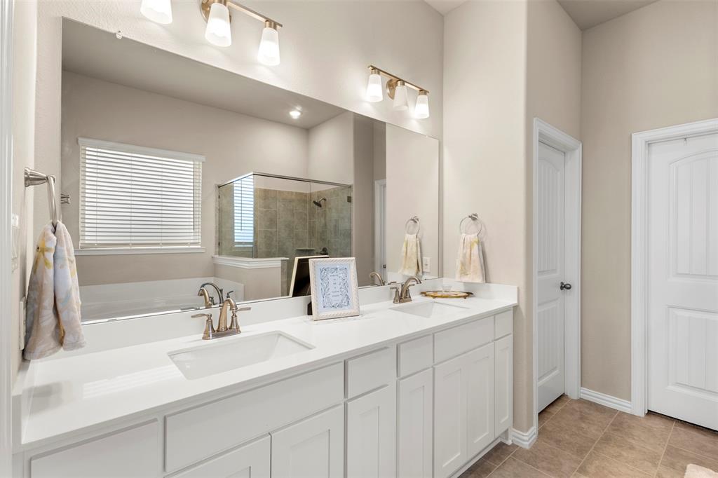 107 Yampa Court Rhome, TX 76078 - Photo 21 of 30 Double vanity featuring white shaker-style cabinetry, undermount sinks, and brushed nickel faucets